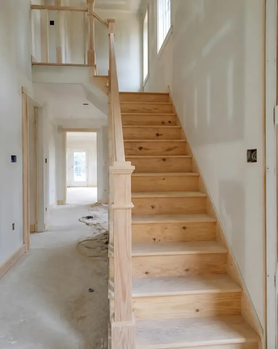Unfinished light wood staircase and railing before painting and staining